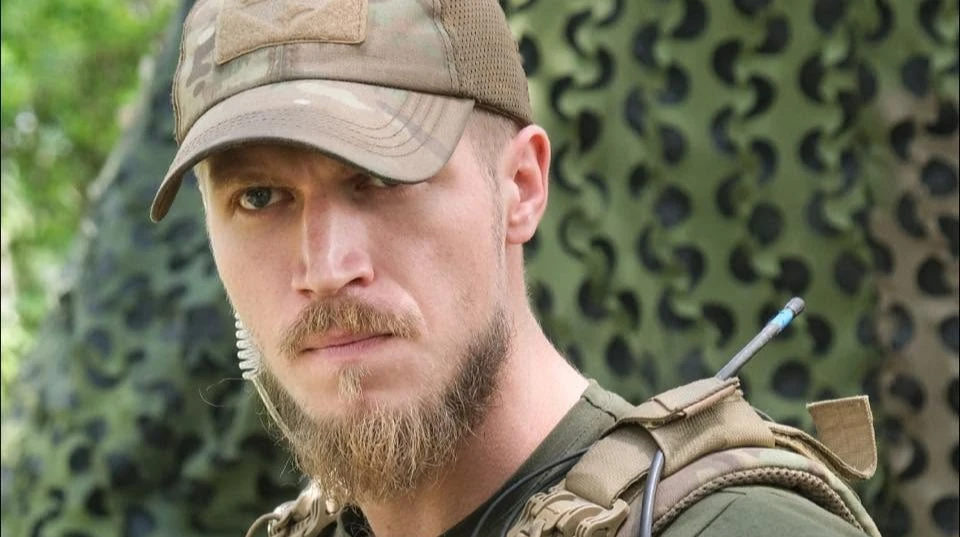 Емблема 16-го армійського корпусу Збройних Сил України на тлі військової техніки